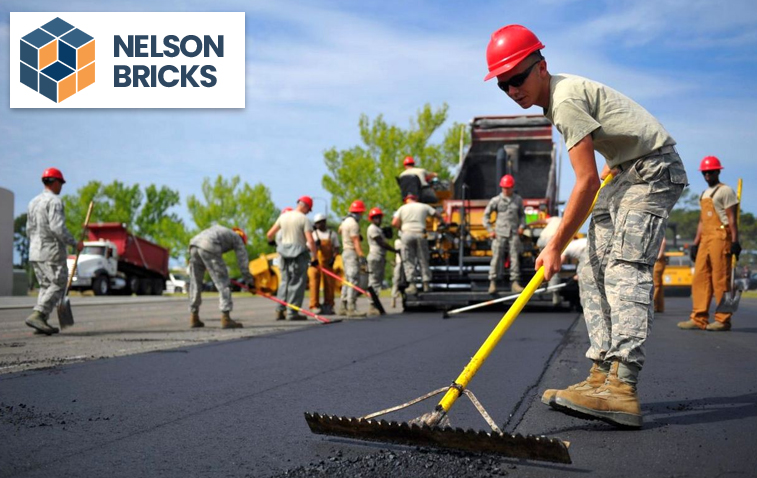 Workers installing a new asphalt road after milling